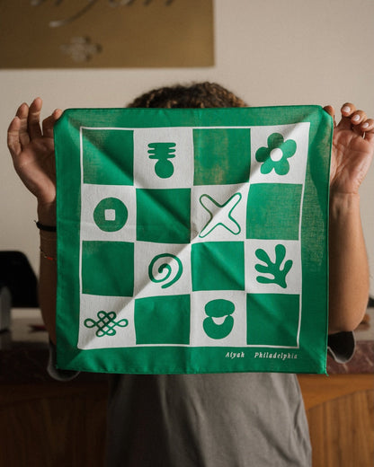 Person holding a green and white patterned bandana with 'Aiyah Philadelphia' branding.